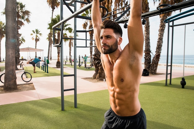 Young man with six pack looking away