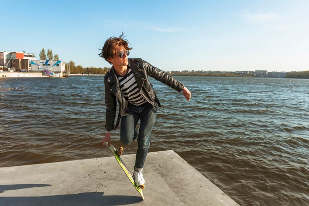 Young man with a skateboard near the sea