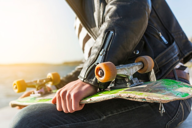 Young man with a skateboard near the sea