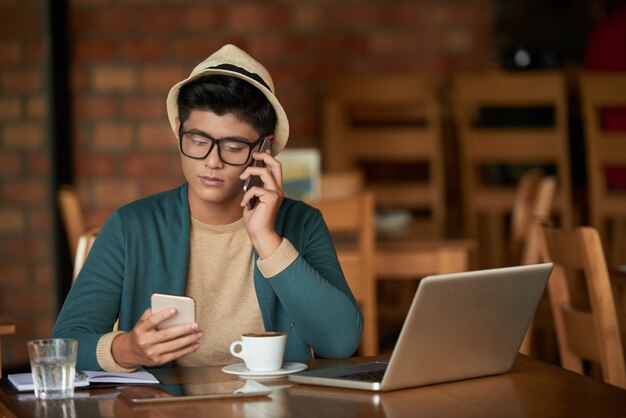 2つの電話を持つ若い男