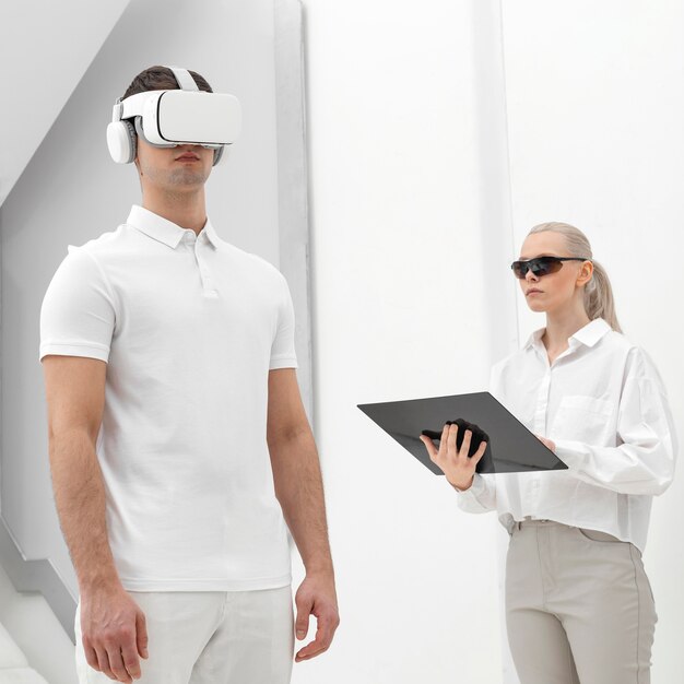 Young man with virtual reality simulator and woman testing