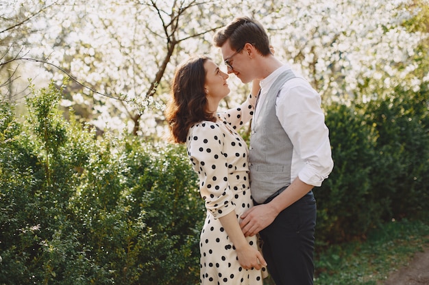 Free photo young man and woman couple in a blooming garden