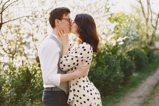 Young man and woman couple in a blooming garden