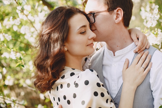 Young man and woman couple in a blooming garden