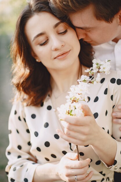 Young man and woman couple in a blooming garden