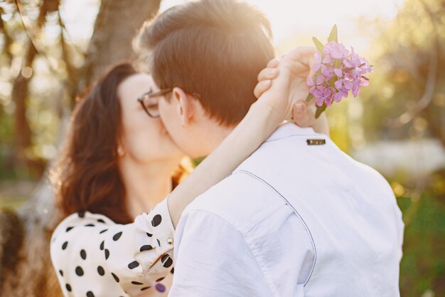 Young man and woman couple in a blooming garden