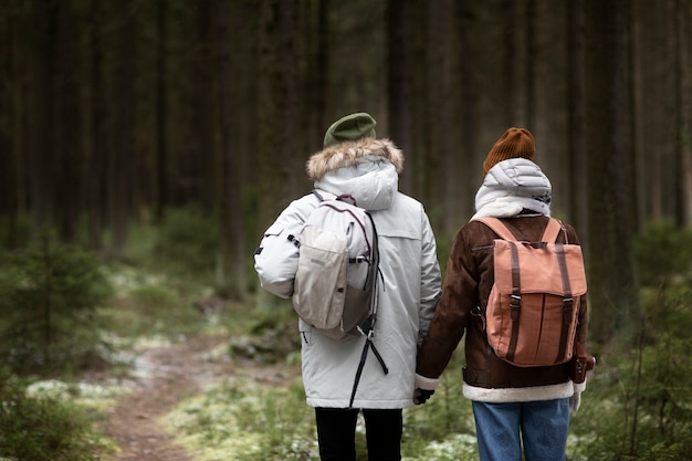 Giovane uomo e donna in una foresta insieme durante un viaggio invernale