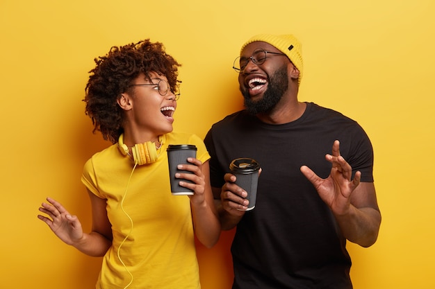 Free photo young man and woman holding cups of coffee