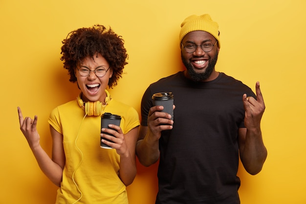 Young man and woman holding cups of coffee