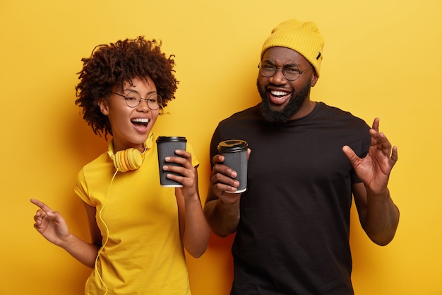 Young man and woman holding cups of coffee