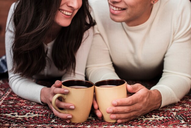 Young man and woman holding mugs