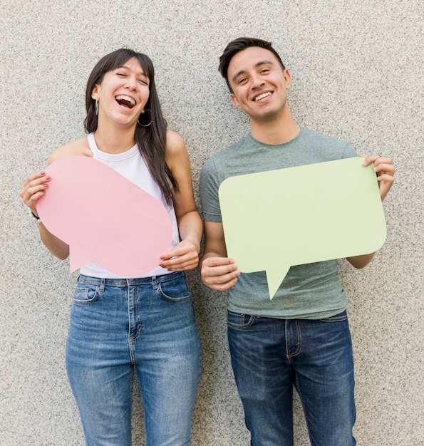 Young man and woman holding speech bubbles