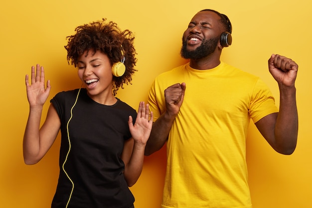 Young man and woman listening to music in headphones