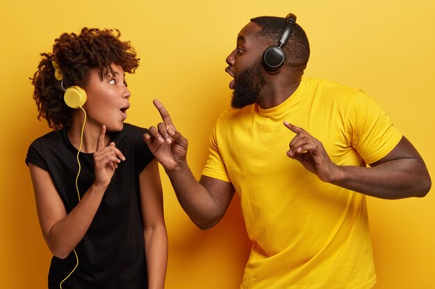 Young man and woman listening to music in headphones