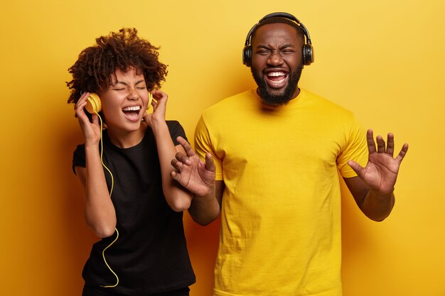 Young man and woman listening to music in headphones