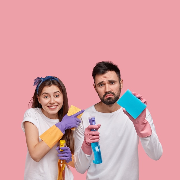 Young man and woman posing with cleaning products