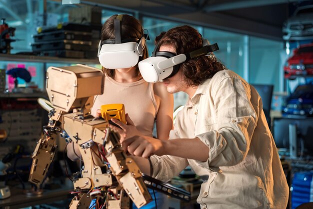 실험실 로봇에서 로봇 공학 실험을 하는 보호 안경을 쓴 젊은 남녀