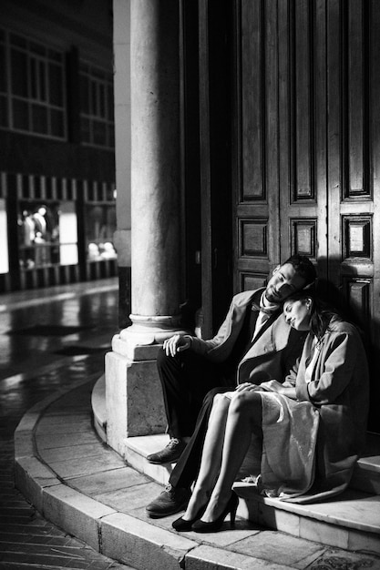 Free photo young man and woman sitting near door on street