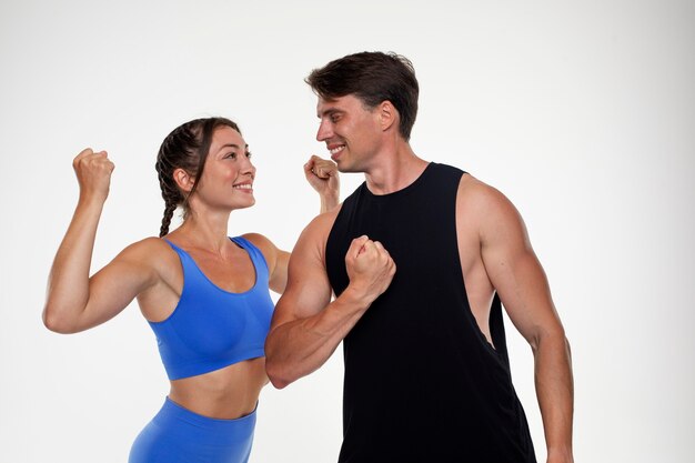 Молодой мужчина и женщина вместе тренируются в бодибилдинге