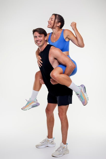 Молодой мужчина и женщина вместе тренируются в бодибилдинге