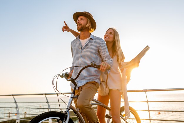 Young man and woman traveling on bicycles, holding map