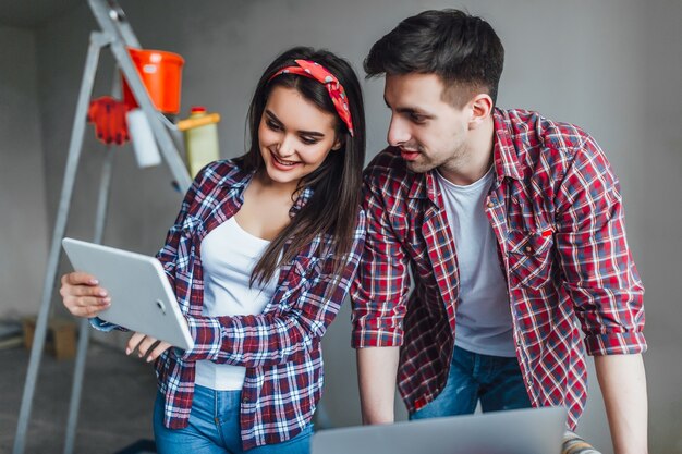 Young man and woman unpleasantly surprised while doing online shopping