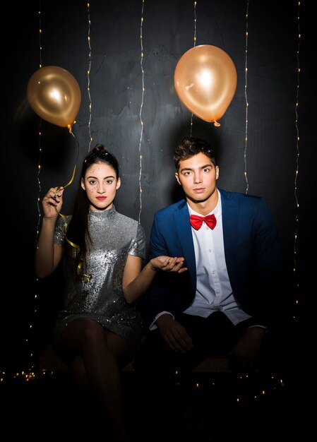 Young man and woman with balloons on bench