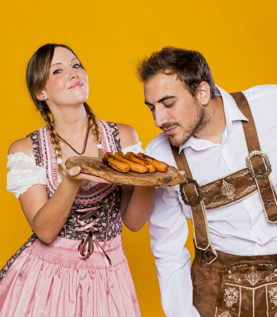 Молодой мужчина и женщина с жареными колбасками