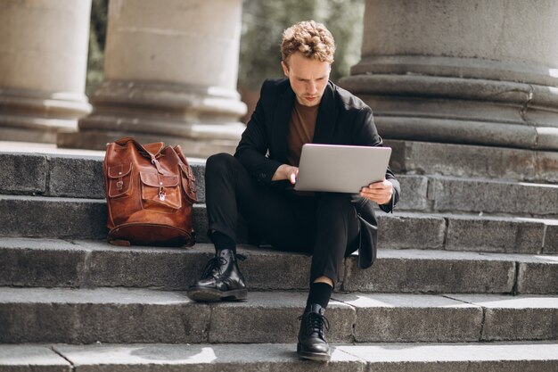 若い男が大学でコンピューターに取り組んで