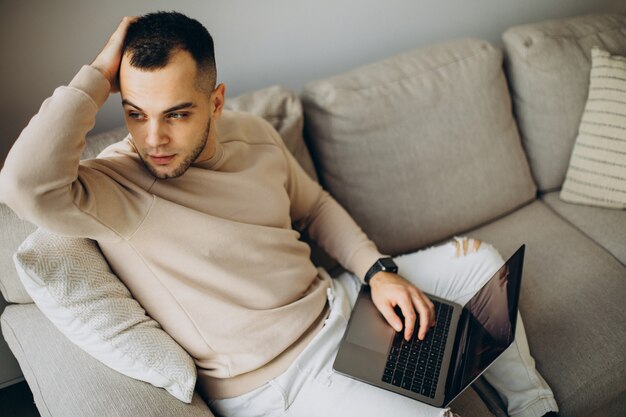 Giovane che lavora da casa sul laptop