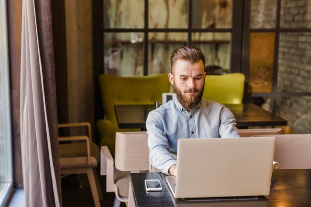 Young man working on laptop in restaurant