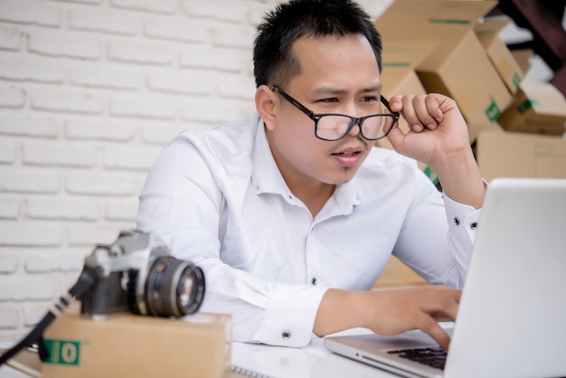 Young man working marketing online with laptop and box post