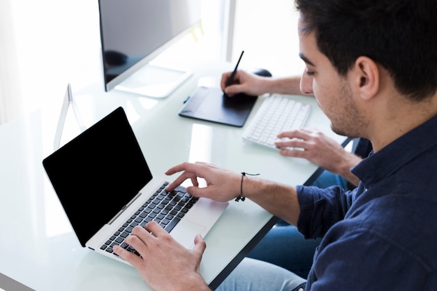 Young man working in office with colleague