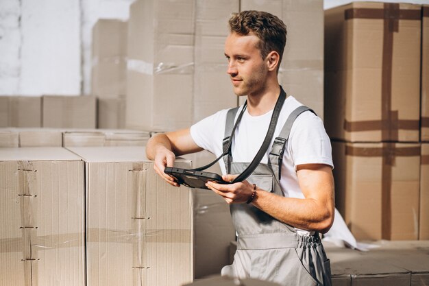 Young man working at a warehouse with boxes