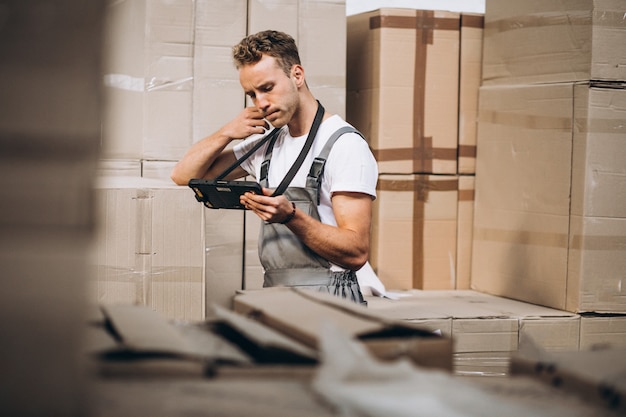 Young man working at a warehouse with boxes