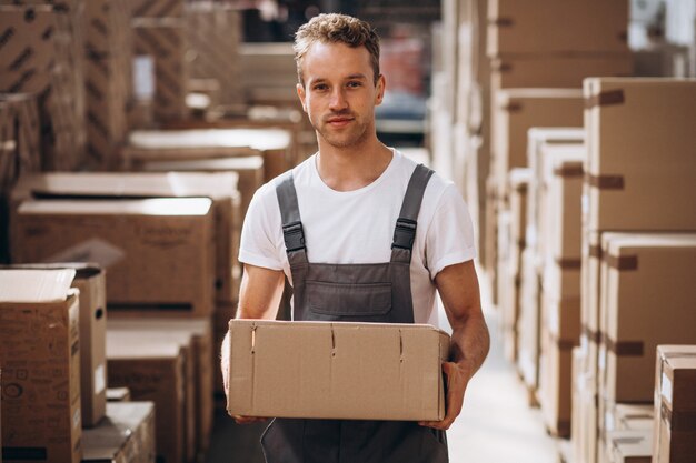 Молодой человек работает на складе с ящиками