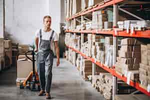 Free photo young man working at a warehouse with boxes