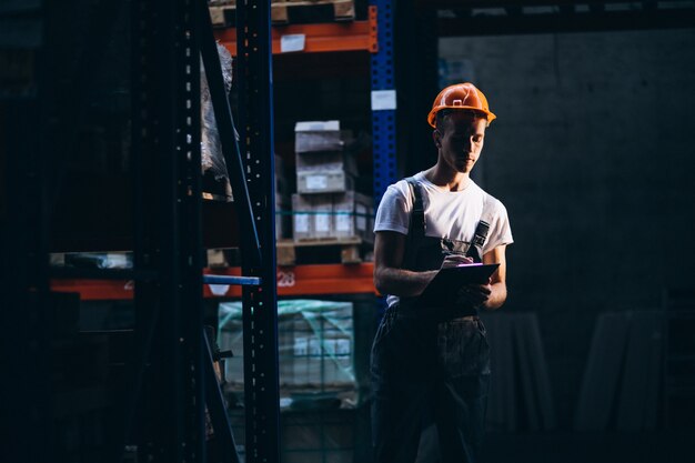 Молодой человек работает на складе с ящиками