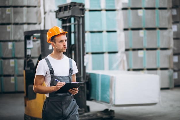 Free photo young man working at a warehouse with boxes