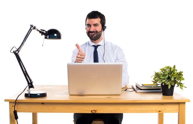 Young man working with a headset with thumb up