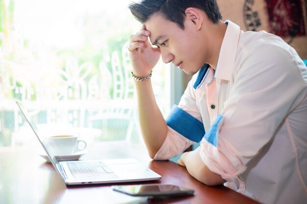 Young man working with laptop in cafe