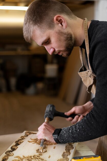 Young man working in a wood engraving workshop