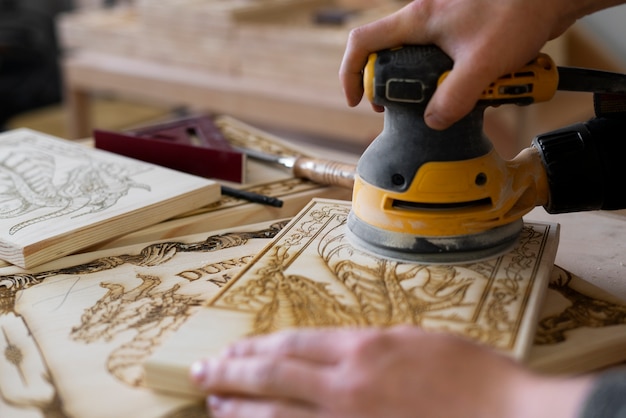 Free photo young man working in a wood engraving workshop