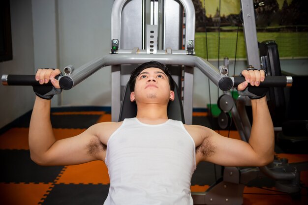 Young man workouts at fitness gym