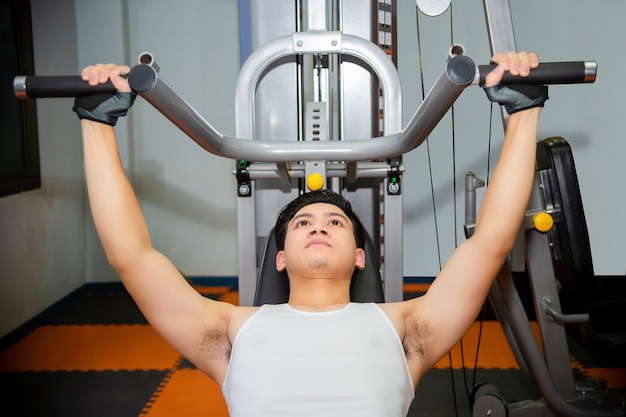 Young man workouts at fitness gym