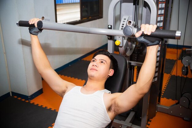 Young man workouts at fitness gym