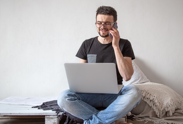 young man works remotely at a computer at home.