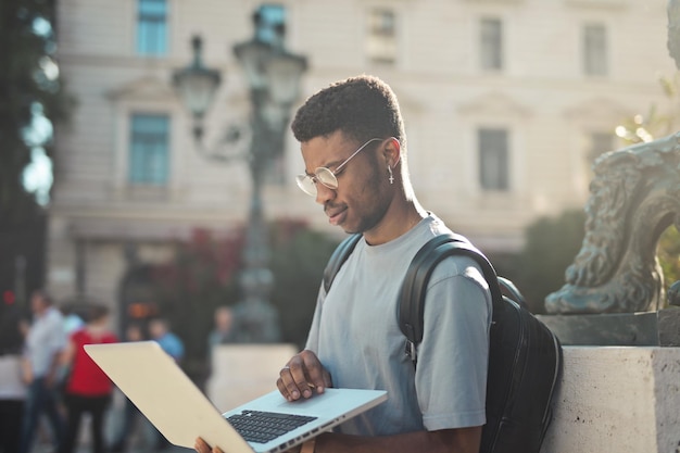 young man works with a computer on the street