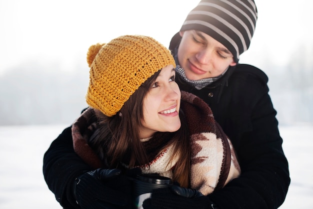 Free photo young man wrapping his girlfriend into blanket