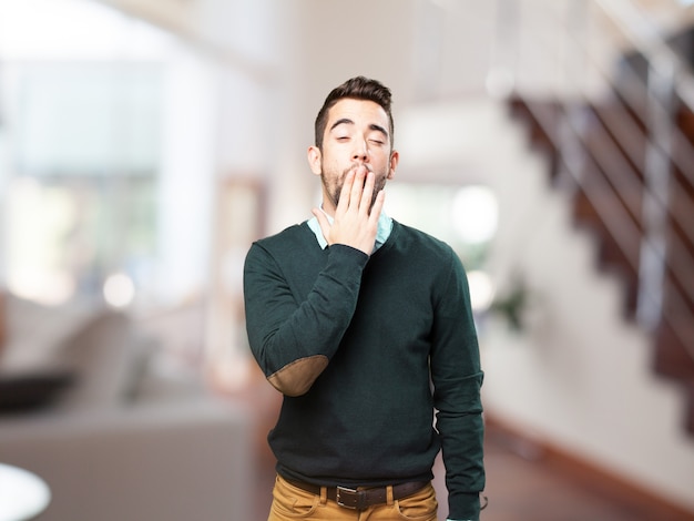 Young man yawning with blurred background